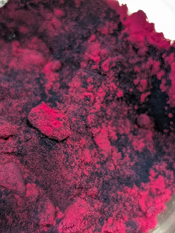A close up blend of powdered beetroot and indigo extract pigments